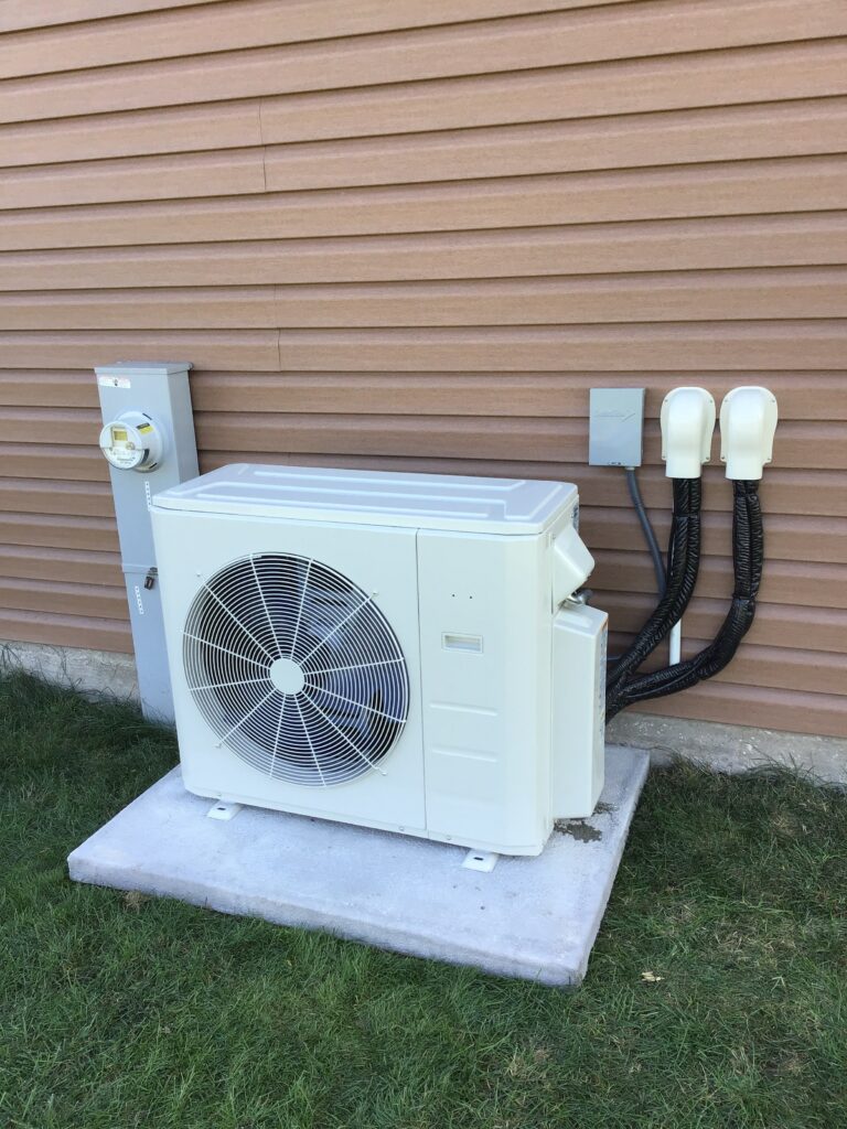 Ductless mini-split on the side of a house.