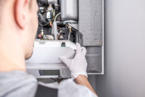 Close Up Of Technician Fixing Central Heating Furnace System.